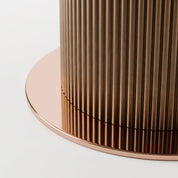 Ariano Dinning Room Table close-up showing fluted bronze metal pedestal base and round tabletop edge.