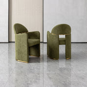 Bodrum dining room chair in olive green velvet with a curved back and gold metal base, showcasing a modern, sculpted