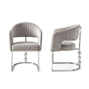 Front and side view of a Cristallo dining room chair with grey velvet upholstery, channel tufting, and a chrome base with