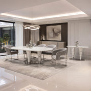 Cristallo dining room table with white marble top and chrome pedestal bases in a modern dining area.