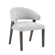 Contemporary Delphi dining room chair upholstered in light grey fabric with dark wooden legs, shot from a slightly elevated