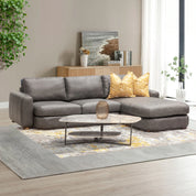 Hickory L-Shape Lounge Suite in grey leather look with yellow patterned cushions in a modern living room.