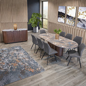 Kali Dining Room Chair in dark grey fabric with a sleek contoured back and slim black legs, shown around a marble dining