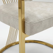 Marcello Dining Room Chair close-up showing a light gray upholstered seat cushion with polished gold metal frame.