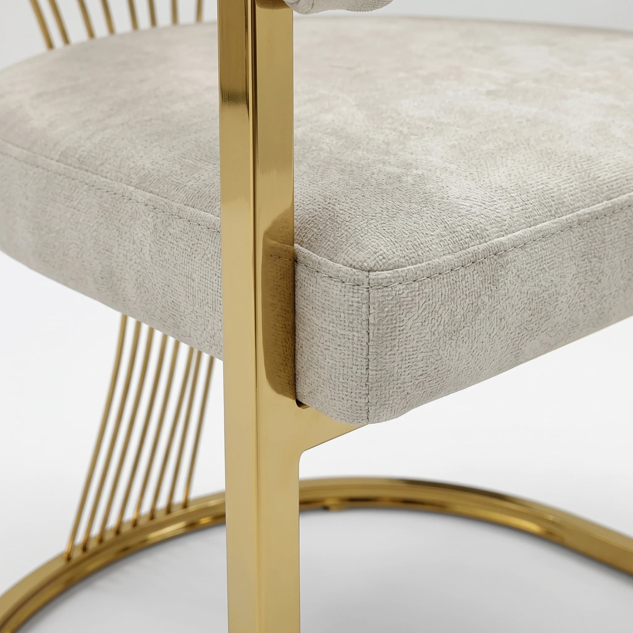 Marcello Dining Room Chair close-up showing a light gray upholstered seat cushion with polished gold metal frame.