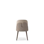 Back view of a Reims Dining Room Chair featuring a beige upholstered seat and a textured backrest panel, supported by dark