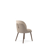 Reims dining room chair, upholstered in beige fabric with a textured back and dark wooden legs, viewed from the back-right.