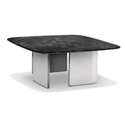 Modern Rovigo coffee table featuring a dark marble top and sturdy white block legs, viewed from an angled perspective.