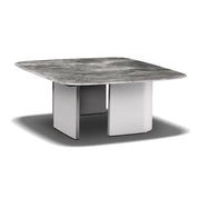 Rovigo coffee table with a square gray marble top and white rectangular legs, presented at an angle on a white background.