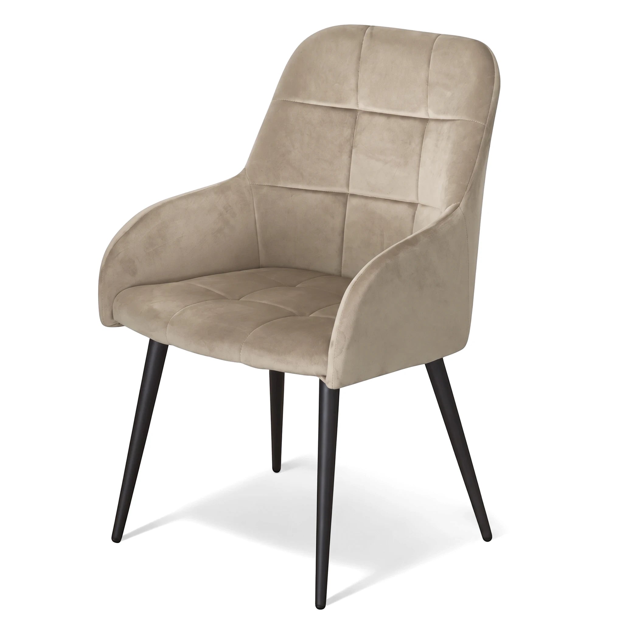 Beige velvet Santos dining chair with quilted back and seat, curved arms, and black tapered metal legs, viewed at an angle.