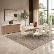 Shimmer Dining Room Table in cream finish with a round top, paired with beige upholstered chairs in a modern dining set.