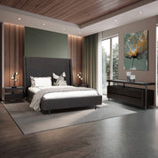 Sierra Pedestal - Brown beside a dark upholstered bed in a contemporary bedroom with lamps and artwork.