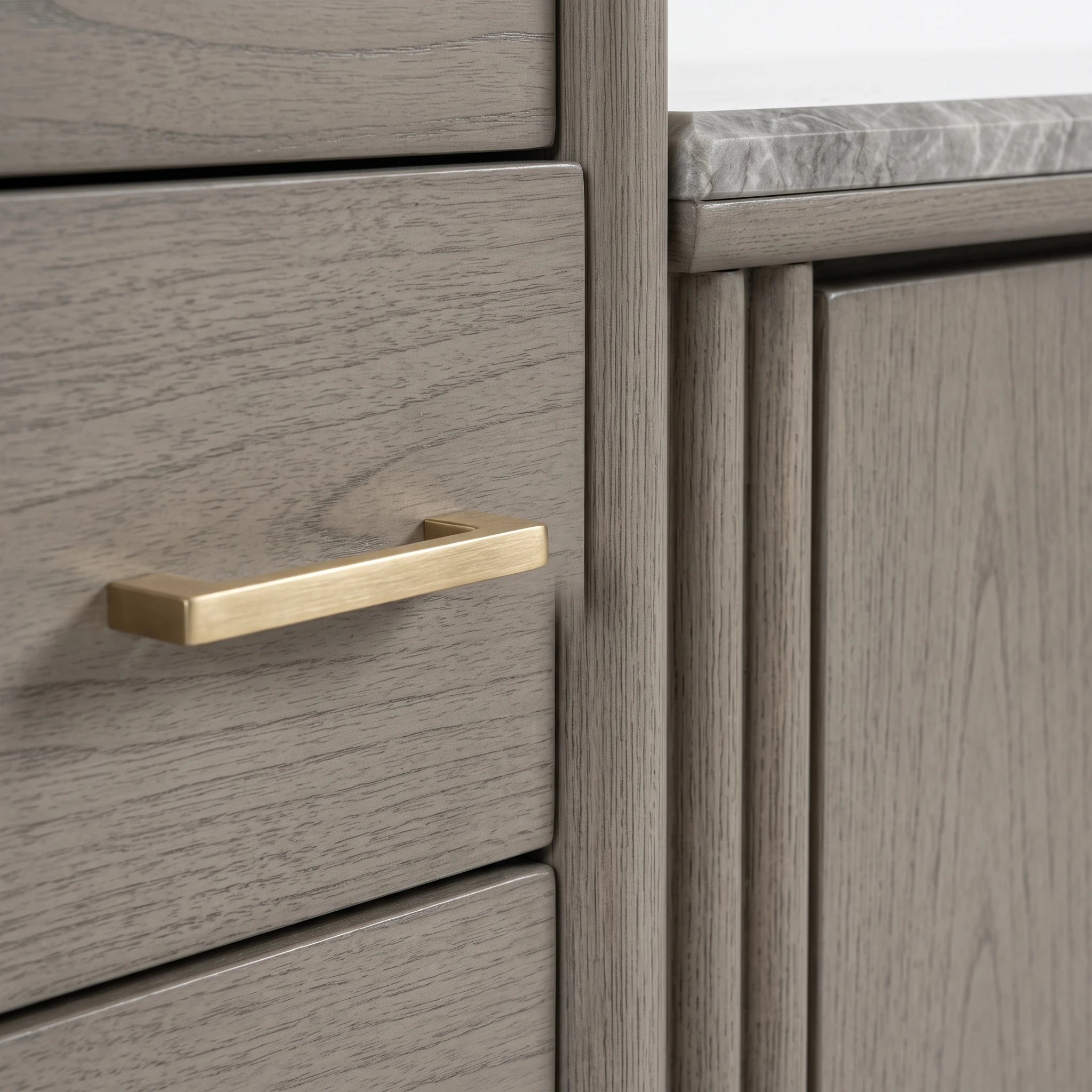 Tazmyn Sideboard in grey oak, close-up of wood grain drawer front with brushed brass handle and top edge