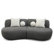 Dark grey textured Witney sofa with a modern curved design, featuring two square and two round white decorative pillows.